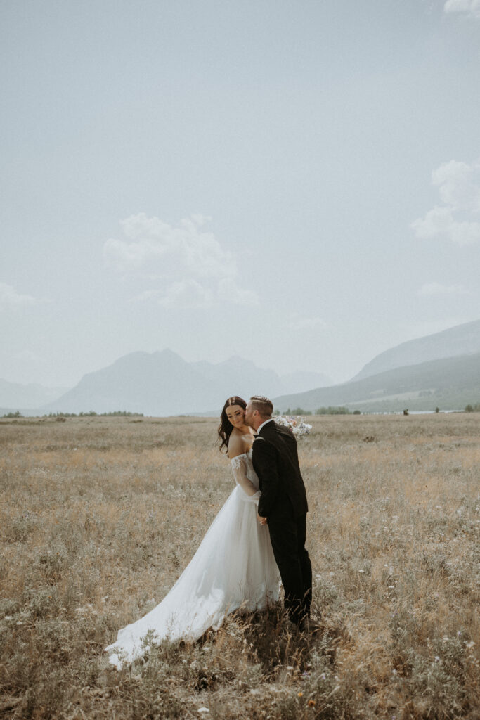 Cute picture of the groom kissing the bride on the cheek