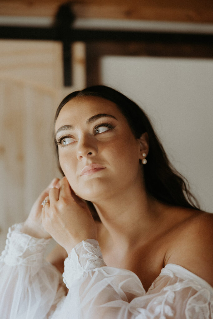 Bride putting on her jewelry before the ceremony