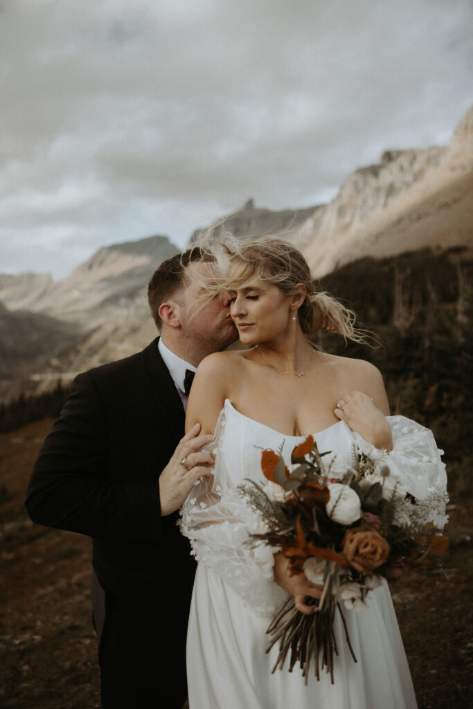 Groom, kissing the bride on the cheek