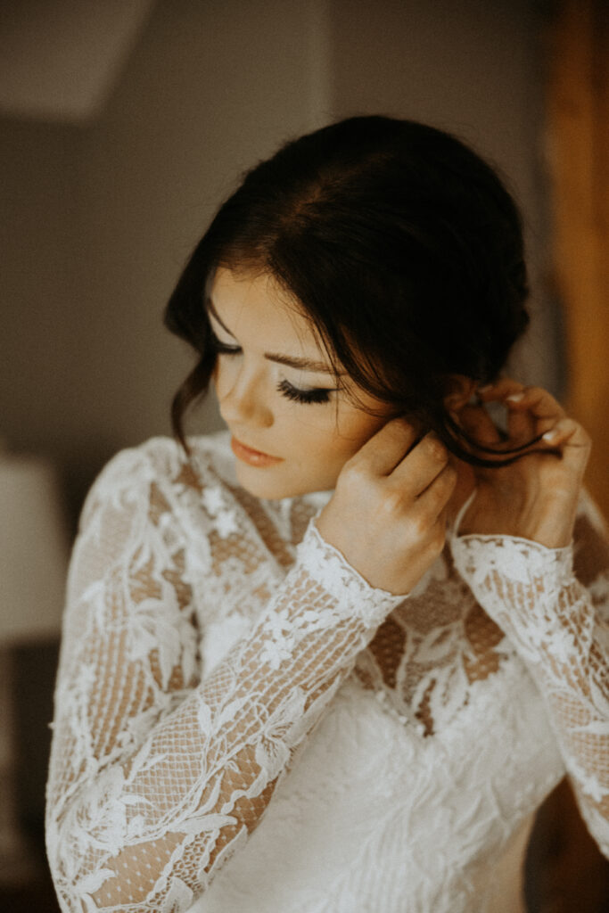 bride putting on her jewelry before her first look with the groom
