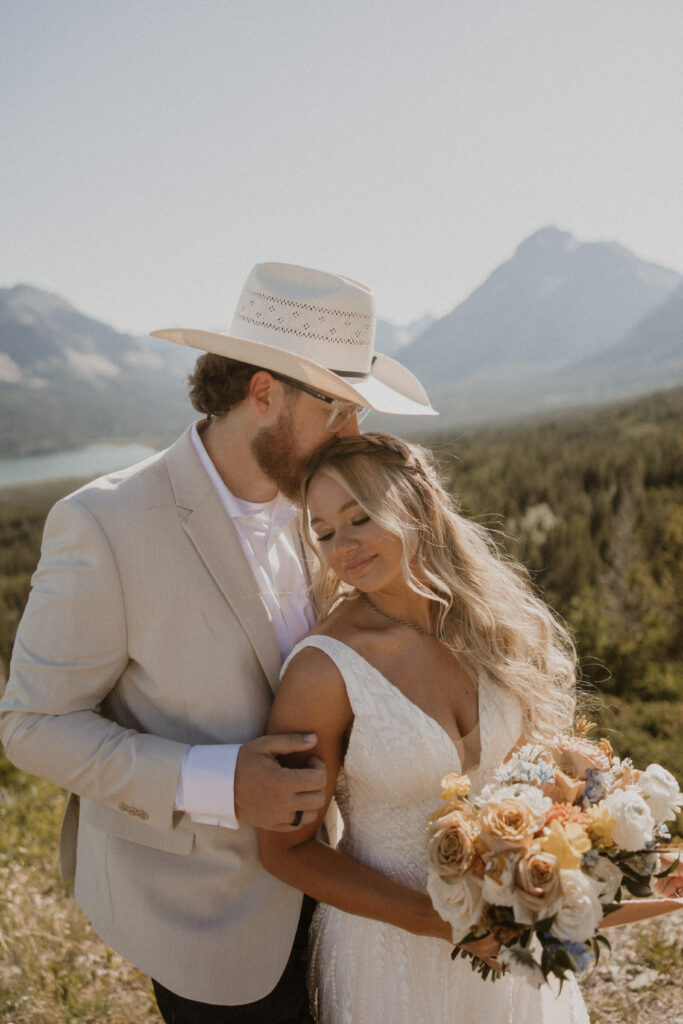 Groom, kissing the bride on the forehead