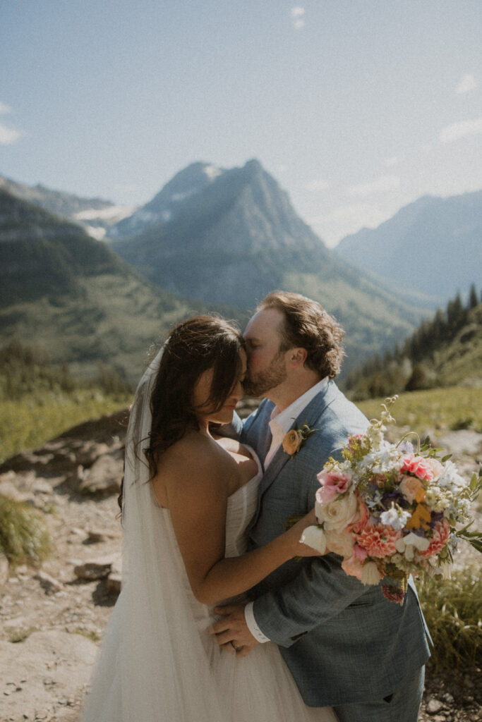 Groom, kissing the bride on the forehead