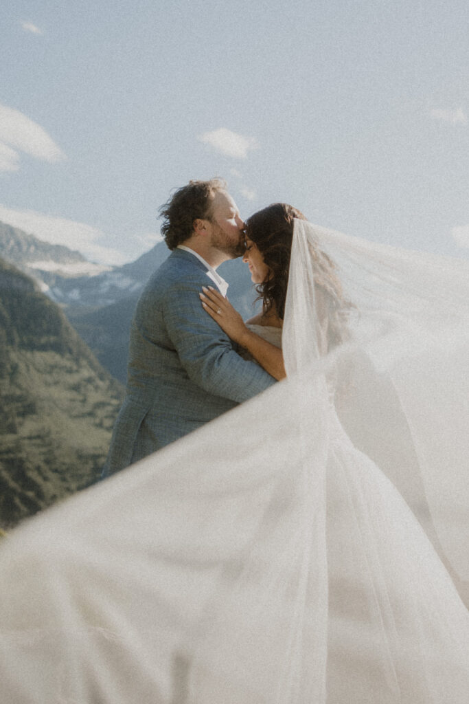 Groom, kissing the bride on the forehead
