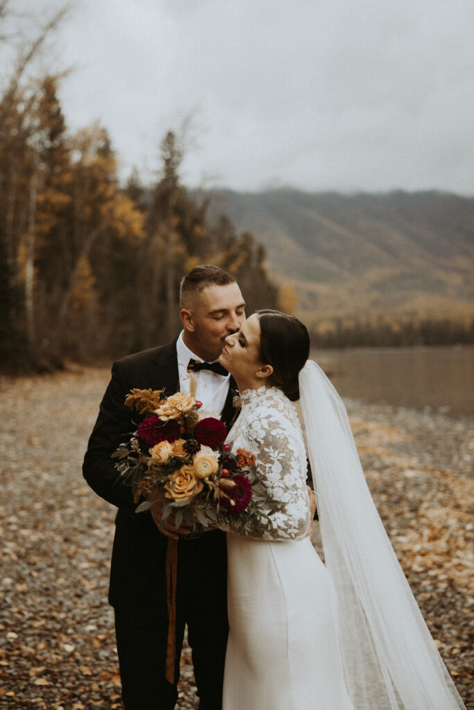 Groom, kissing the bride on the cheek