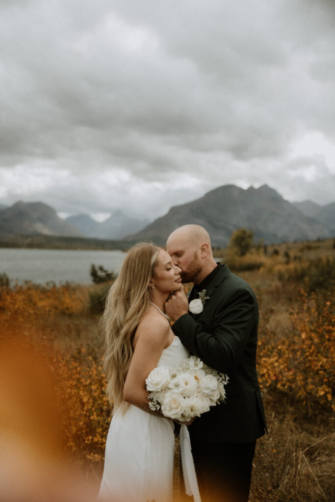 groom kissing the bride on the cheek