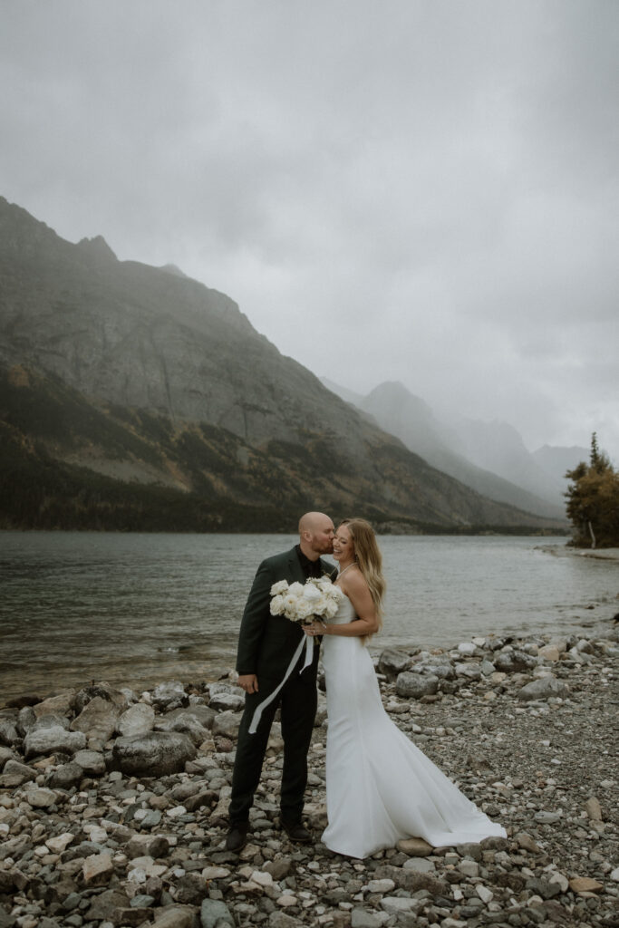 groom kissing the bride on the cheek