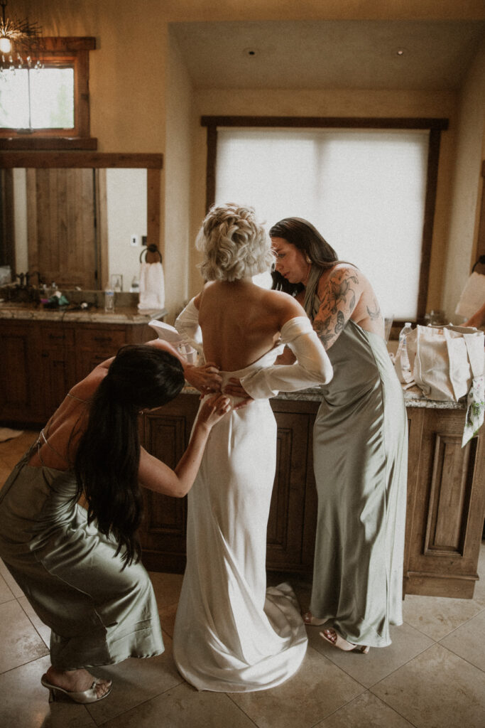 bridesmaids helping the bride with her wedding dress