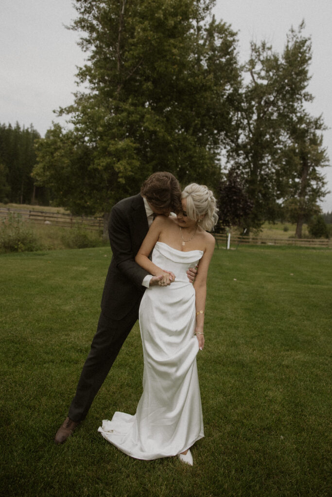groom kissing the bride on the shoulder